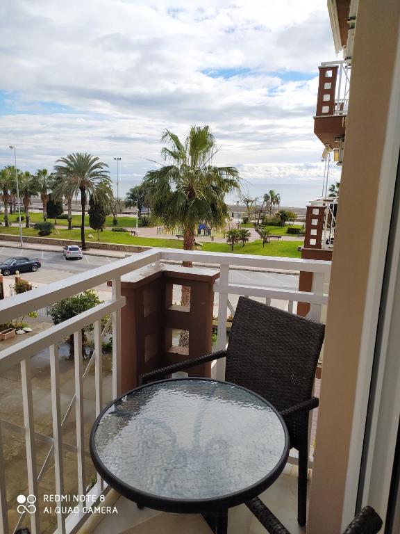 stół i krzesło na balkonie z widokiem na ulicę w obiekcie Apartamento playa con vistas al mar w mieście Torre del Mar