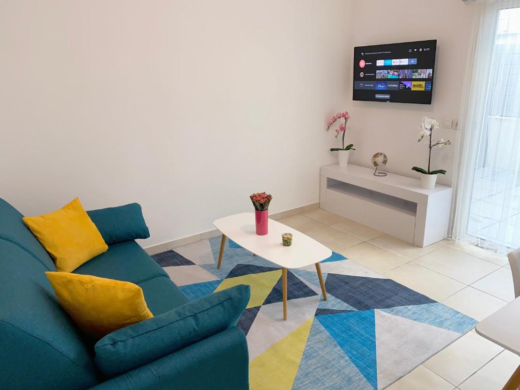馬賽的住宿－Appartement la plage de la pointe rouge，客厅配有蓝色的沙发和桌子