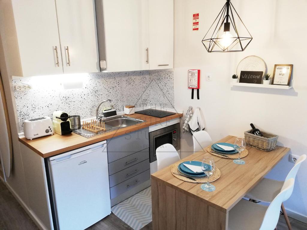 a small kitchen with a table and a sink at The Surf Studio - Ericeira in Ericeira