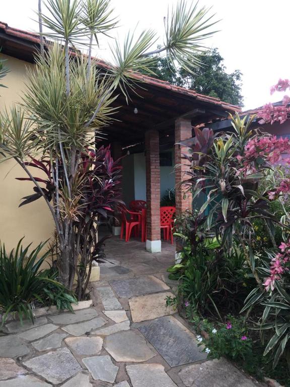 a garden with a patio with palm trees and plants at Casa da Dona Ilda in Pirenópolis