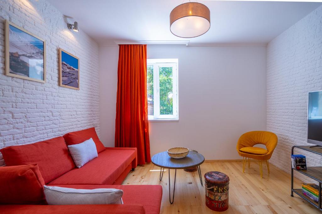 sala de estar con sofá rojo y mesa en svaneti apartment's, en Mestia