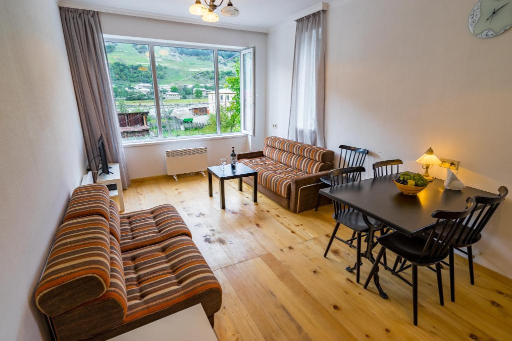 a living room with a couch and a table at Svaneti Apartment's - Cozy Mountain Apartments in Mestia in Mestia