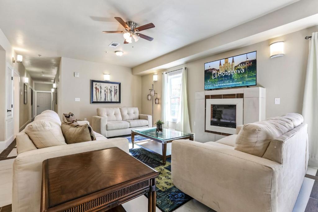 a living room with white furniture and a flat screen tv at Stunning Condos Near French Quarter in New Orleans