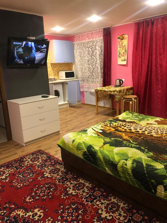 モンチェゴルスクにあるApartments on Ulitsa Leninaのベッドルーム1室(ベッド2台、壁掛けテレビ付)