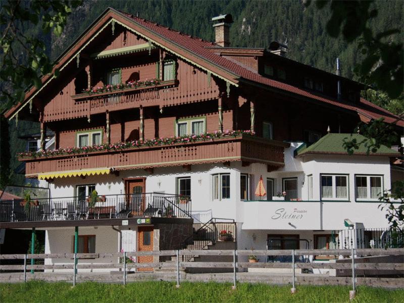 a large wooden house with a balcony on the side at Pension Steiner in Mayrhofen