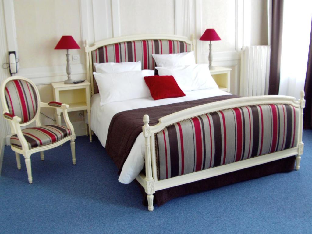 sypialnia z 2 łóżkami i krzesłem w obiekcie Le Grand Hotel w mieście Cherbourg en Cotentin