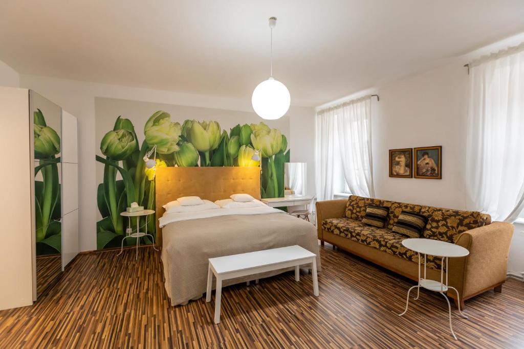 a bedroom with a bed and a couch at Palác Daun - Studio Apartments in Znojmo