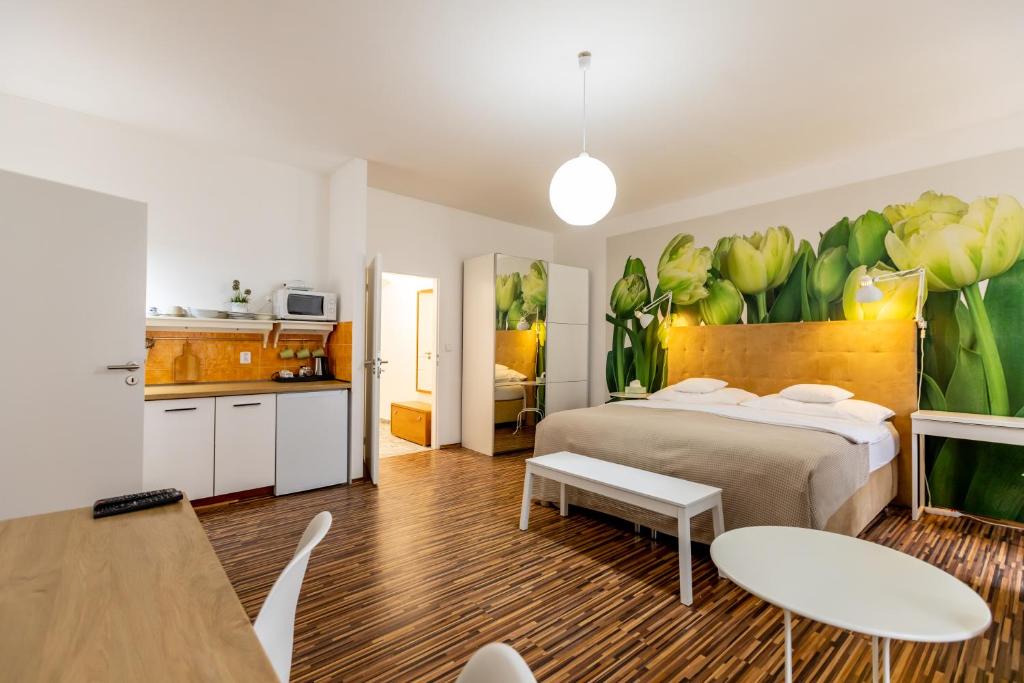 a bedroom with a large bed and a kitchen at Palác Daun - Studio Apartments in Znojmo