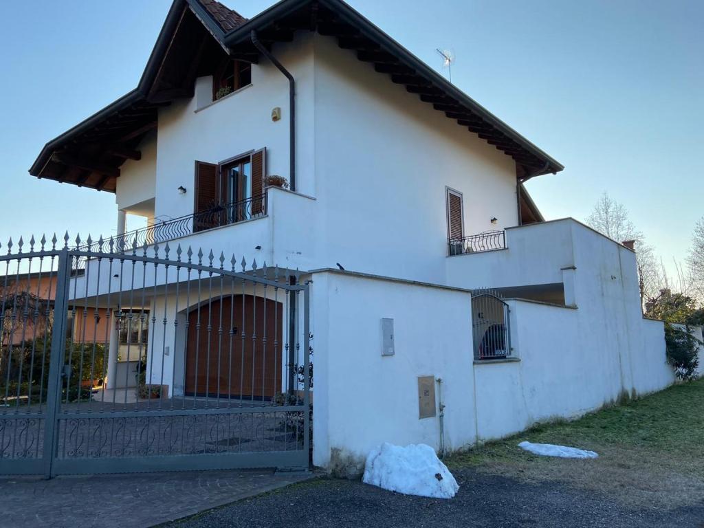 uma casa branca com um portão e uma cerca em Villa Dina em Olgiate Olona