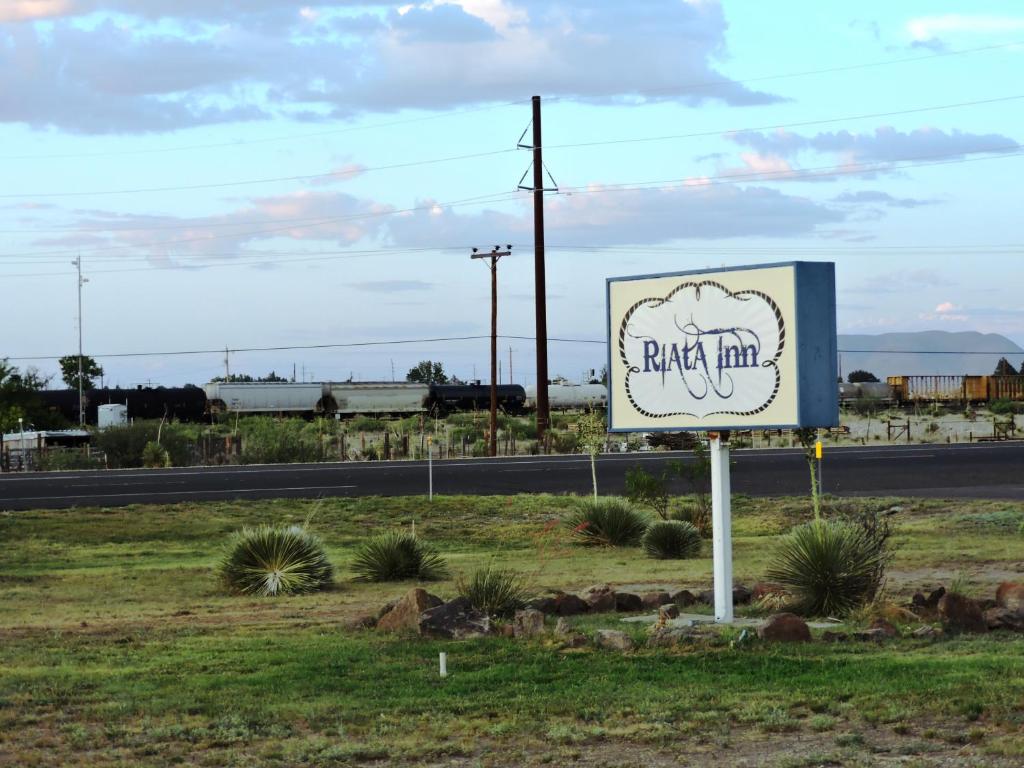 a sign for a park inn on the side of the road at Riata Inn - Marfa in Marfa