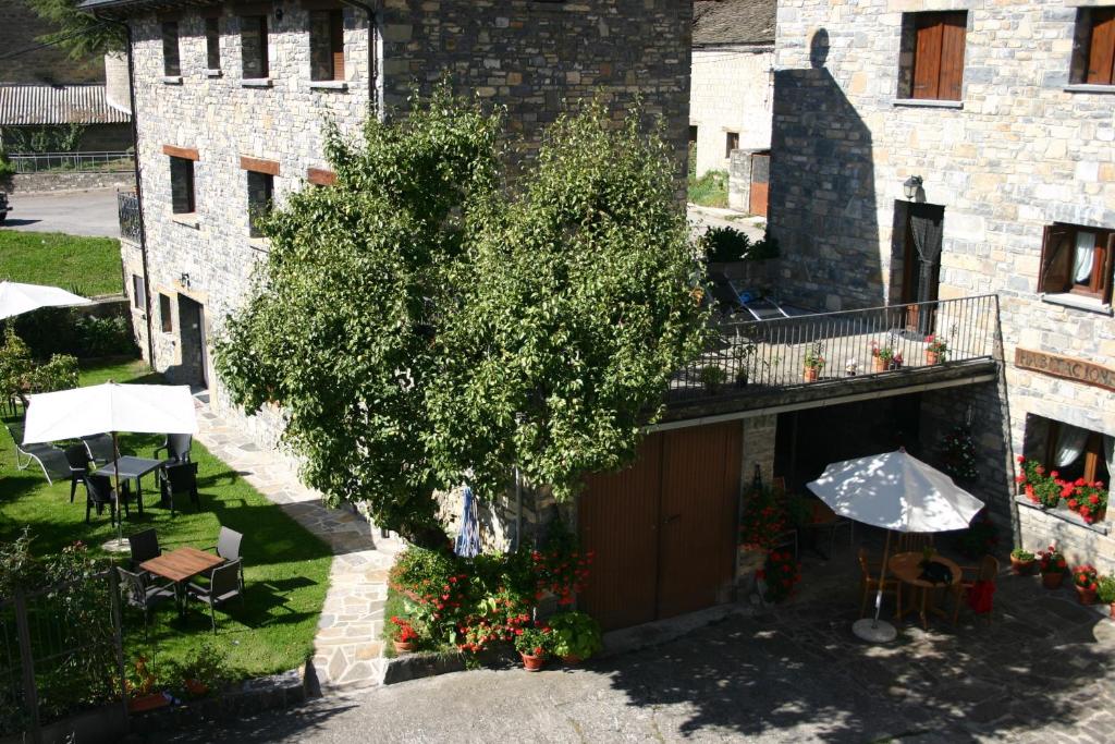 un edificio con un árbol al lado de un edificio con sombrilla en Apartamentos Casa Gallan, en Sarvisé