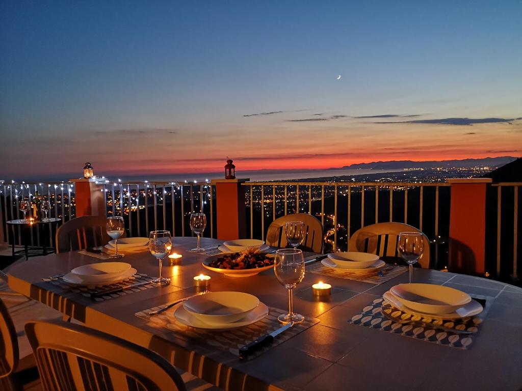 a table with plates and wine glasses on a balcony at Il Castello di Monteggiori in Camaiore