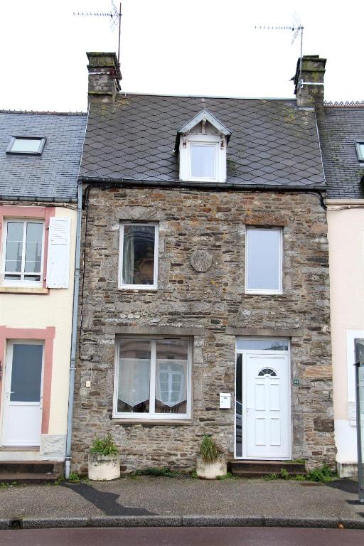 une maison en pierre avec des fenêtres blanches et une porte blanche dans l'établissement La Patelle, à Barneville-Carteret