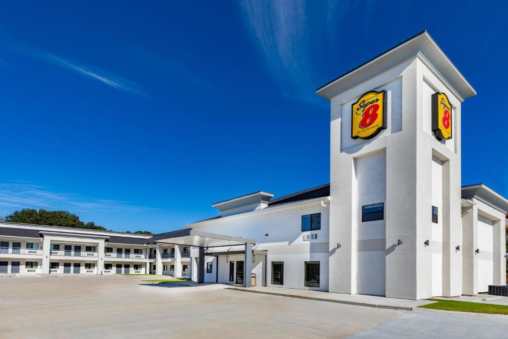 a large white building with a fast food restaurant at Super 8 by Wyndham Houston NW Beltway 8-West Rd in Houston