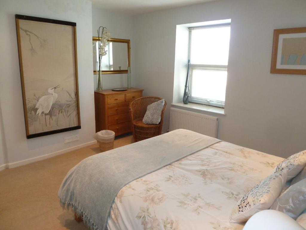 a bedroom with a bed and a dresser and a window at Seapinks Cottage in Portland