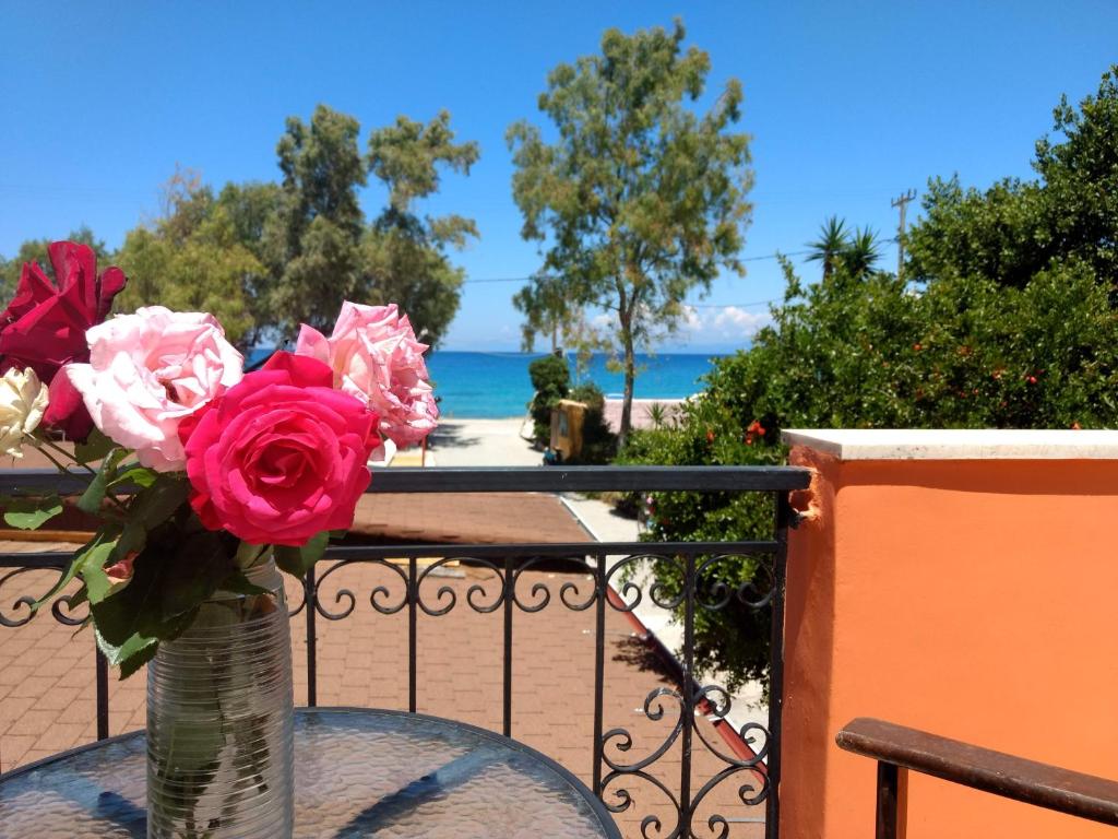a vase of roses sitting on a table on a balcony at Tilegrafos Studios in Lefkada