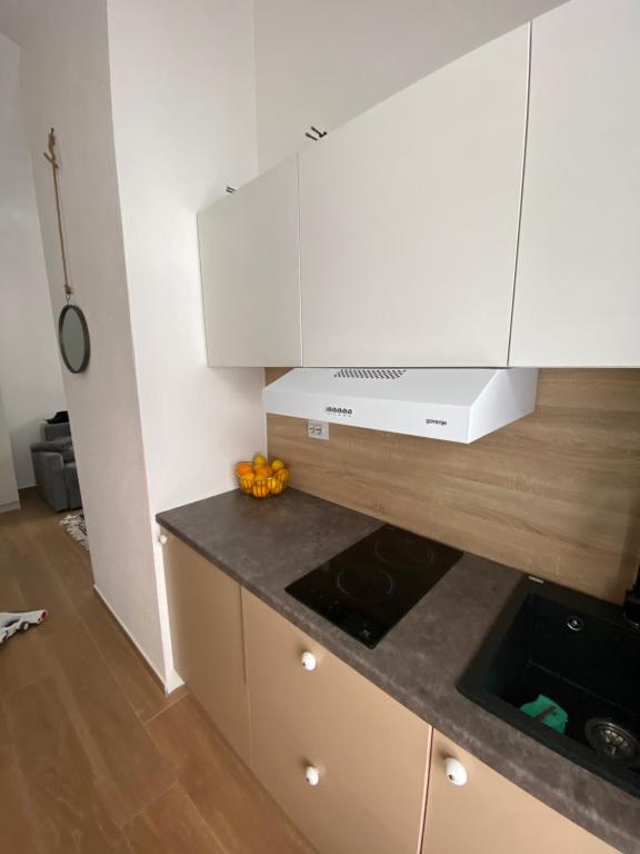 a kitchen with white cabinets and a counter top at Apartman Maris in Šišava