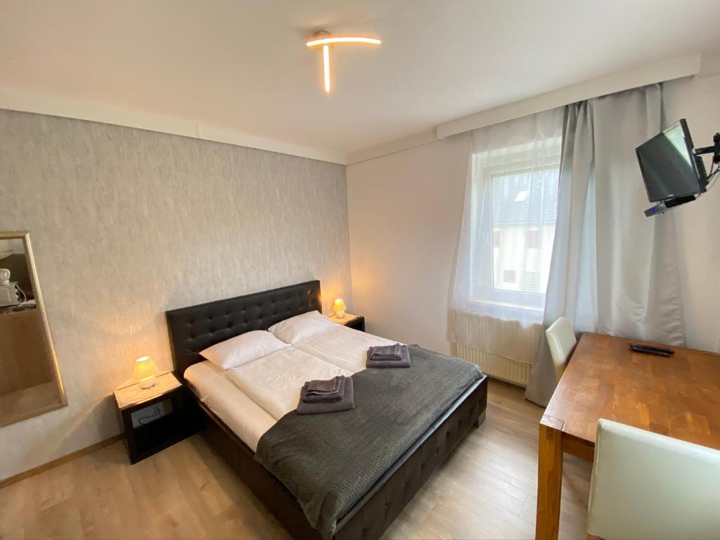 a bedroom with a bed and a table and a window at Pension Günther in Graz
