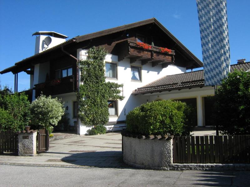 ein weißes Haus mit einem Zaun davor in der Unterkunft Haus Scheucher - Chiemgau Karte in Inzell