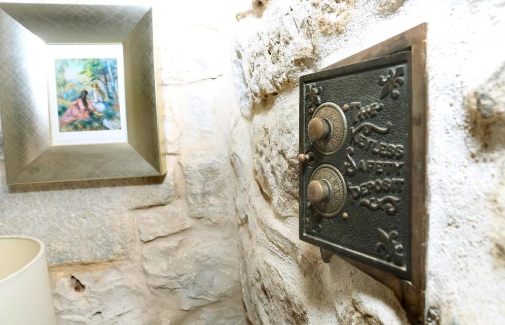 a metal box on a stone wall with a mirror at Palace Wall Residences in Split