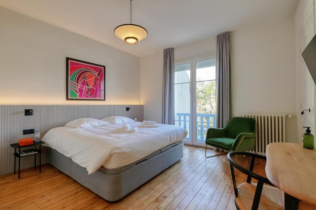 1 dormitorio con 1 cama grande y 1 silla verde en Villa Berry Centre Deauville - Chic & Stylée - Magnifique Jardin en Deauville