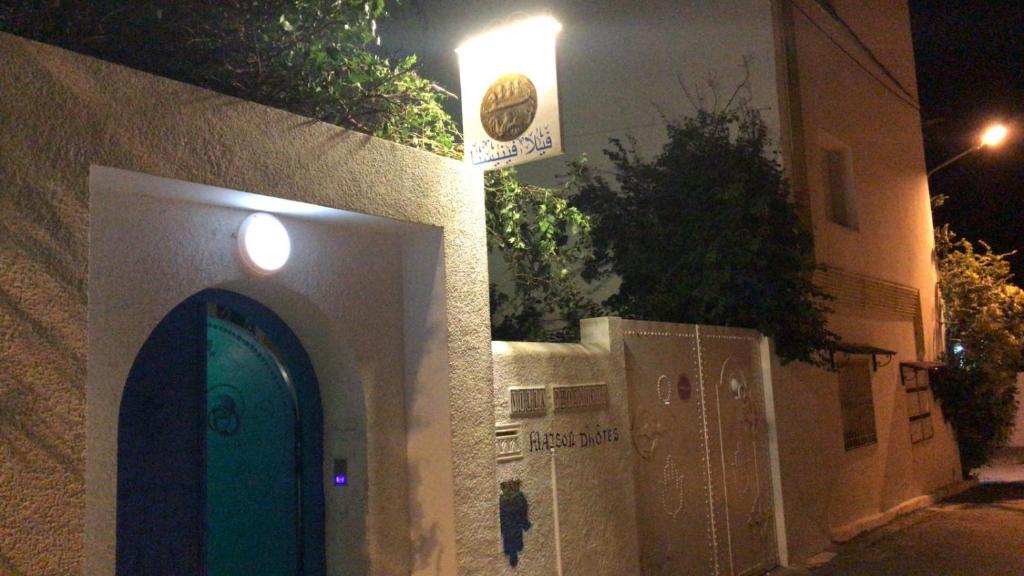 a building with a blue door on a street at night at Villa Phoenicia in Hammamet