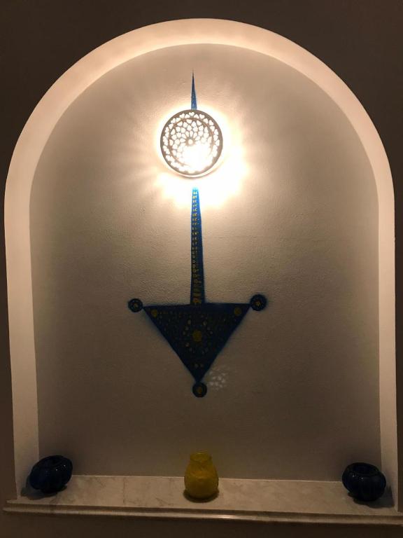 an archway with a lamp and a clock on a wall at Villa Phoenicia in Hammamet