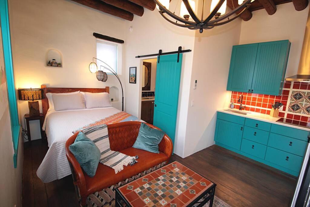 a bedroom with a bed and a couch and blue cabinets at Closson Studio - Stylish - Near Plaza - Queen bed in Santa Fe
