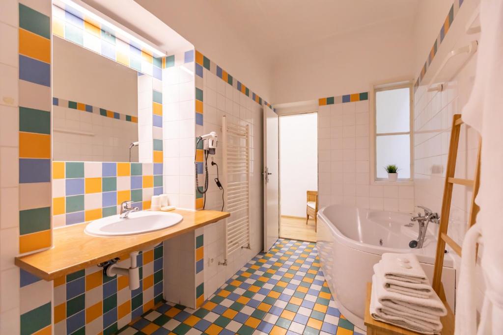 a bathroom with a tub and a toilet and a sink at Palác Daun - Studio Apartments in Znojmo