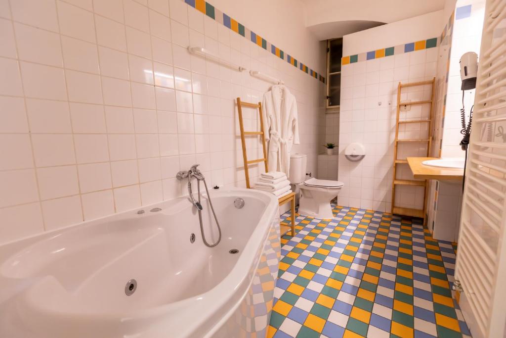 a bathroom with a tub and a tiled floor at Palác Daun - Studio Apartments in Znojmo