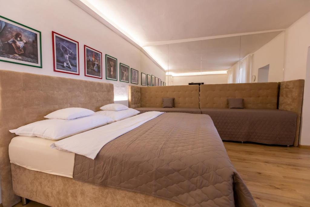 a bedroom with a large bed and a couch at Palác Daun - Studio Apartments in Znojmo