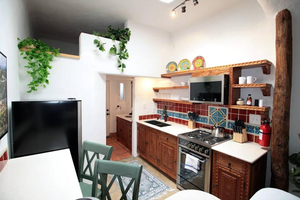 een keuken met houten kasten en een fornuis met oven bij Closson Getaway - Courtyard - Railyard and Plaza in Santa Fe