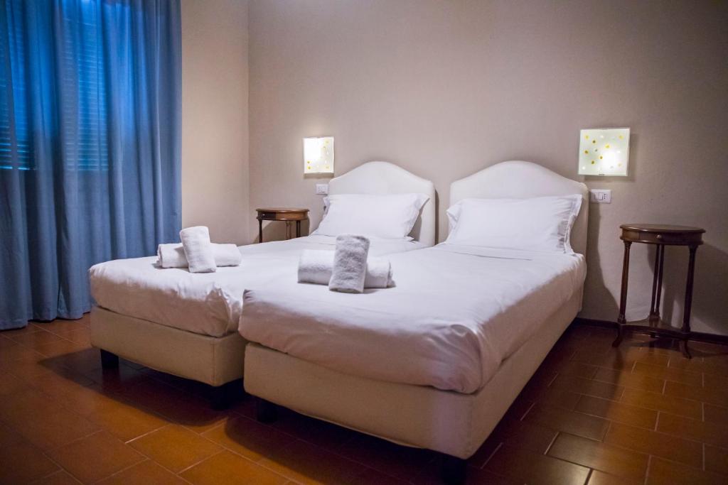 1 dormitorio con 1 cama con sábanas y almohadas blancas en Bastimento, en Fiorenzuola dʼArda