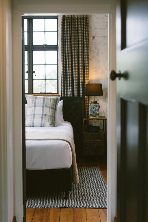 a small bedroom with a bed and a window at The Convent Hotel in Auckland
