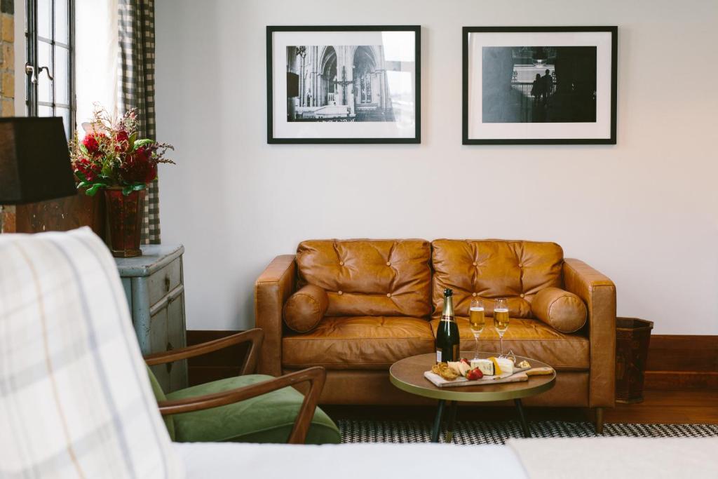 a living room with a brown leather couch and a table at The Convent Hotel in Auckland