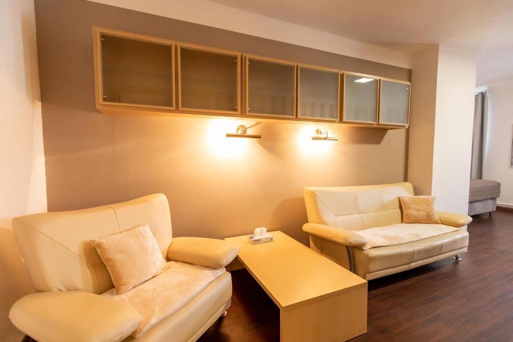 a living room with two chairs and a table at Palác Daun - Studio Apartments in Znojmo
