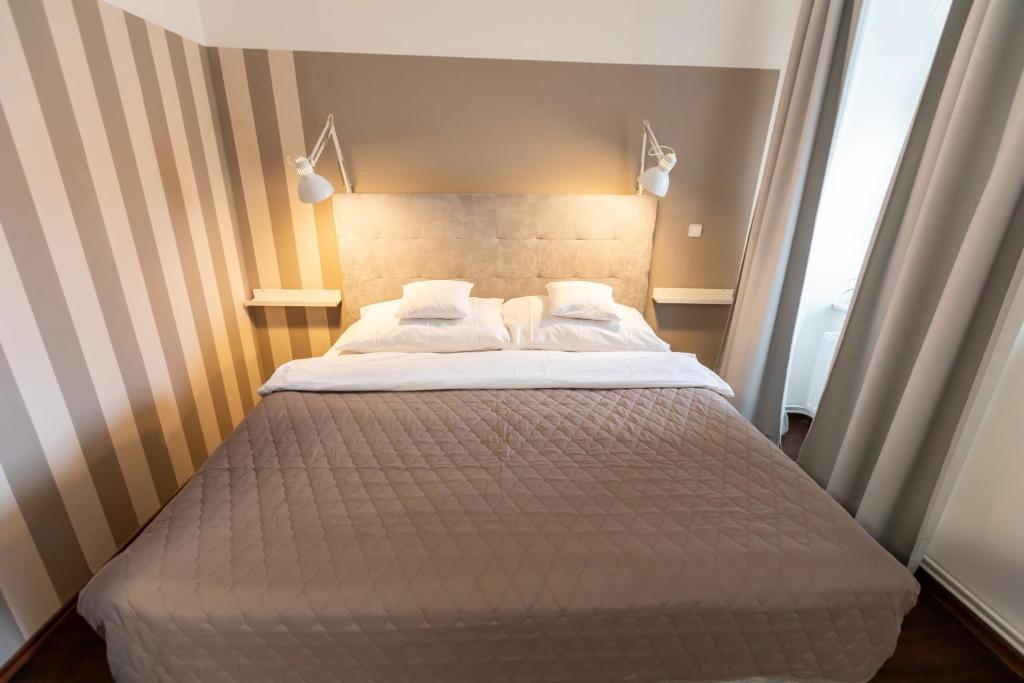 a bed with two pillows on it in a room at Palác Daun - Studio Apartments in Znojmo