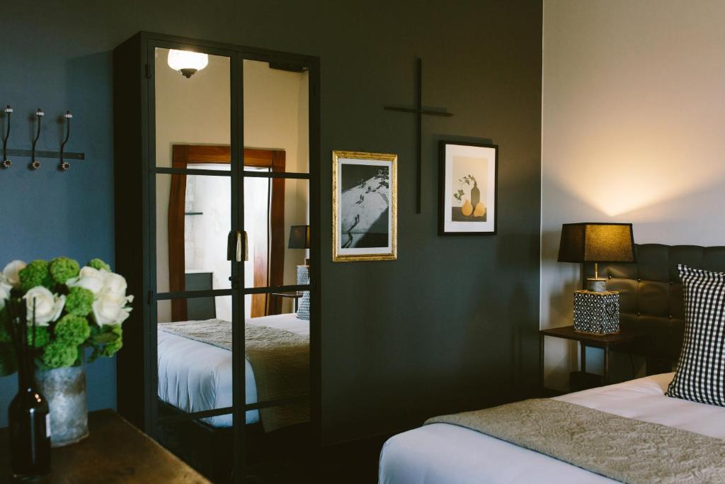 a bedroom with two beds and a mirror at The Convent Hotel in Auckland