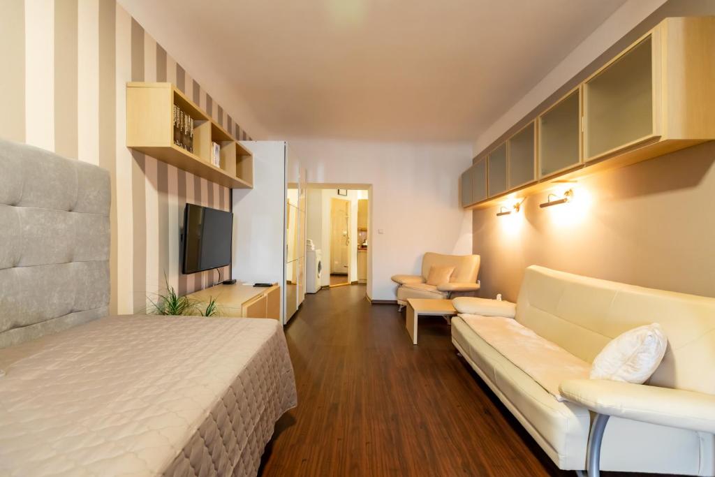 a hotel room with a bed and a couch at Palác Daun - Studio Apartments in Znojmo