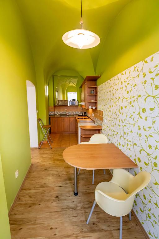 a dining room with green walls and a table and chairs at Palác Daun - Studio Apartments in Znojmo
