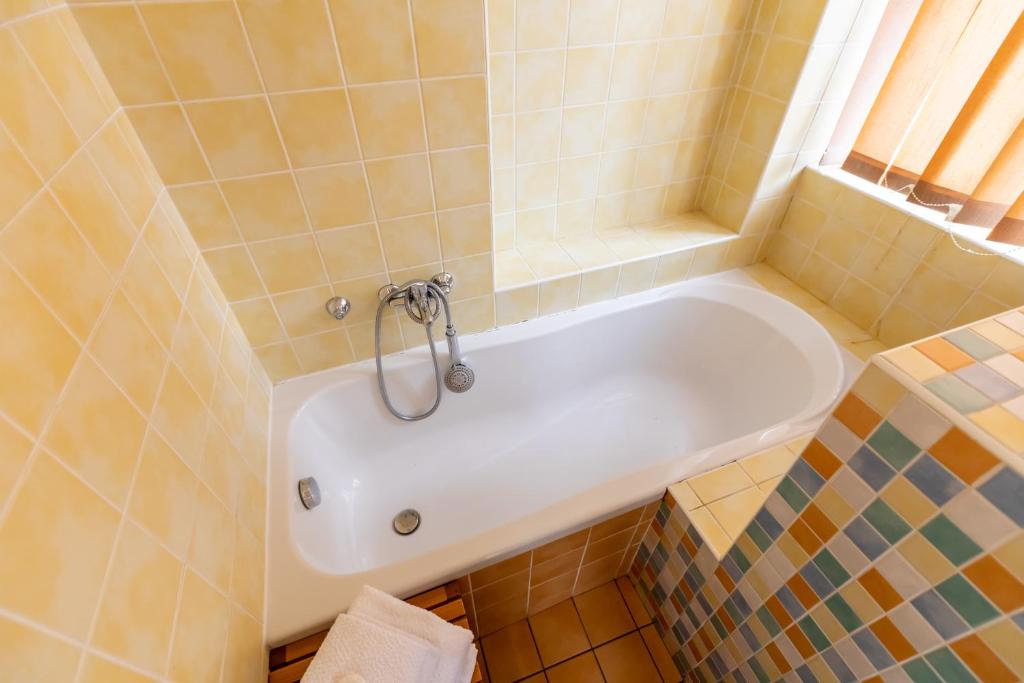 a white bath tub in a bathroom with a window at Palác Daun - Studio Apartments in Znojmo