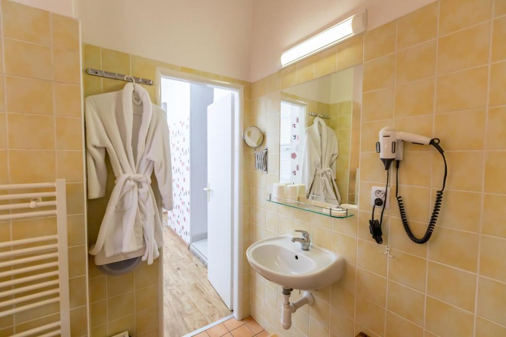 a bathroom with a sink and a mirror at Palác Daun - Studio Apartments in Znojmo