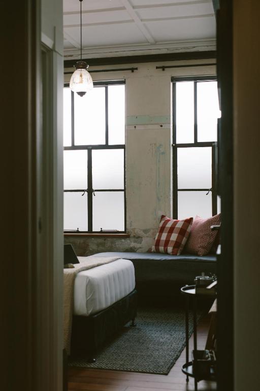 a room with a bed and two windows at The Convent Hotel in Auckland