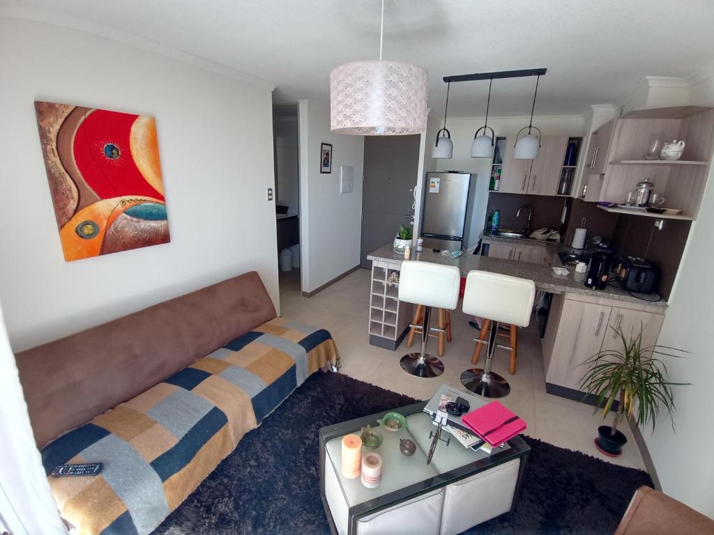 a living room with a couch and a kitchen at DEPARTAMENTO AVENIDA PACIFICO. SECTOR PUERTA DEL MAR in La Serena