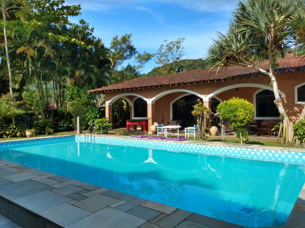 uma piscina em frente a uma casa em Casa com piscina em condomínio fechado no Guarujá em São Paulo