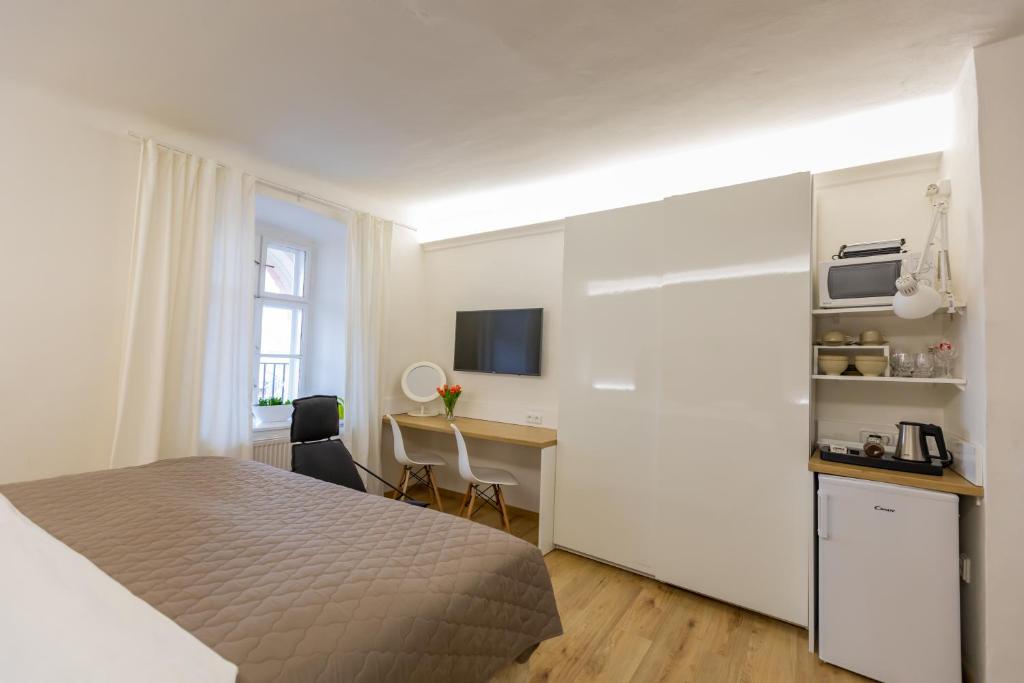 a hotel room with a bed and a desk and a kitchen at Palác Daun - Studio Apartments in Znojmo
