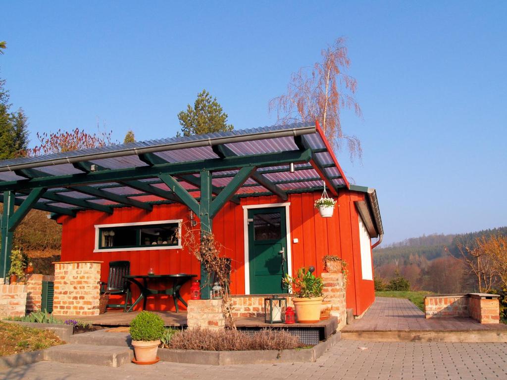 a red tiny house with a green roof at Detached holiday home in the Harz with wood stove and covered terrace in Güntersberge