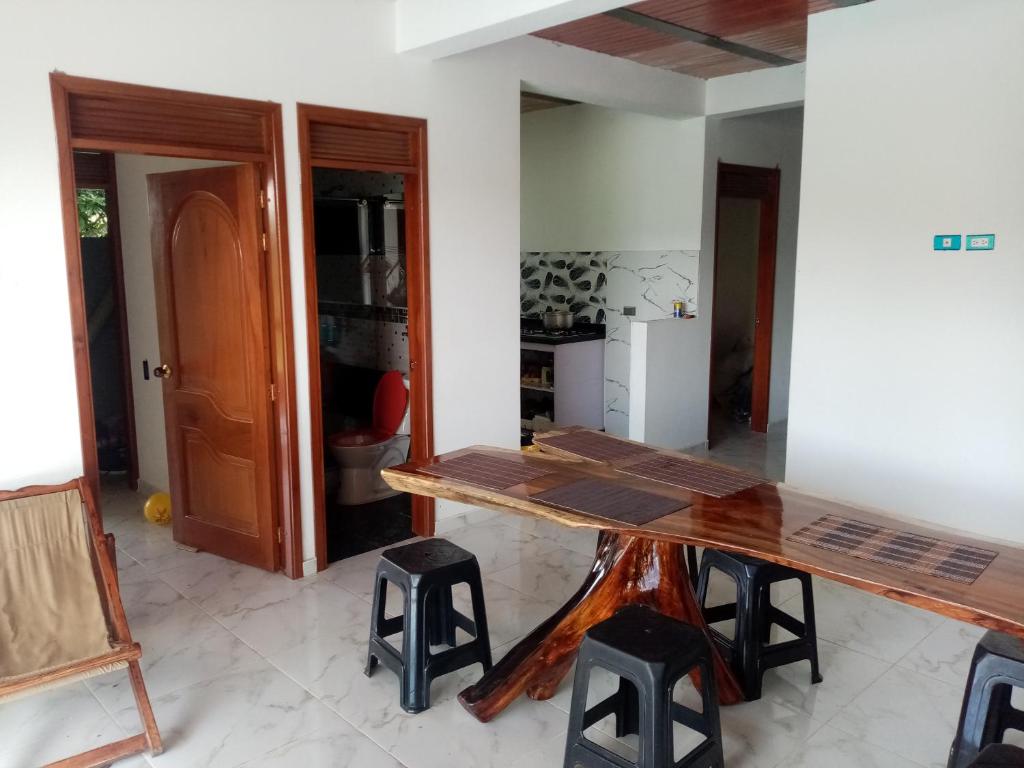 uma sala de jantar com uma mesa de madeira e bancos em Lindo apartamento vacacional en guaduas em Guaduas