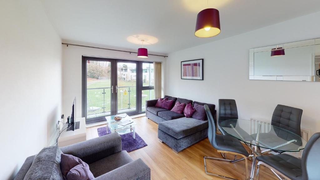 a living room with a couch and a glass table at Niche Parkview Apartments in Brentwood