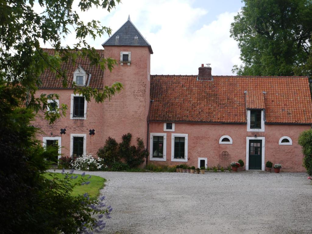 un gran edificio de ladrillo rojo con techo en Gîte de la Ferme Rose, en Audembert